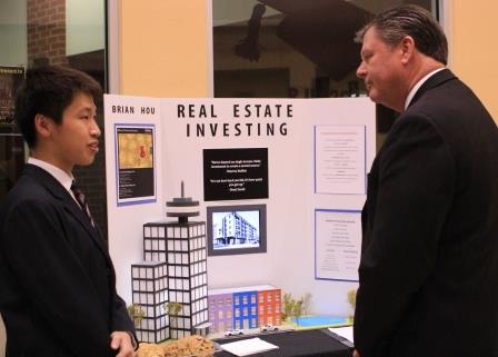 Presenting his findings to Principal Mark Mimms, senior Brian Hou discusses his research on real estate investing. ISM students spent a semester researching a potential career, including working with a mentor already in the field.