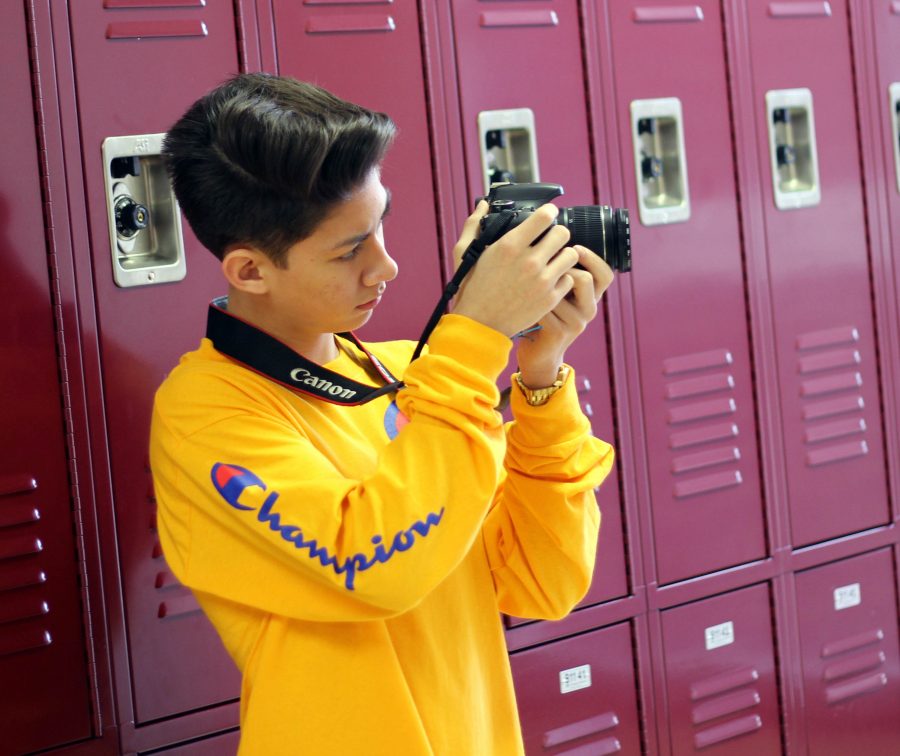 Holding his camera, freshman Blayze Ferguson frames his subject. Blayze taught himself how to shoot making photography his main hobby.