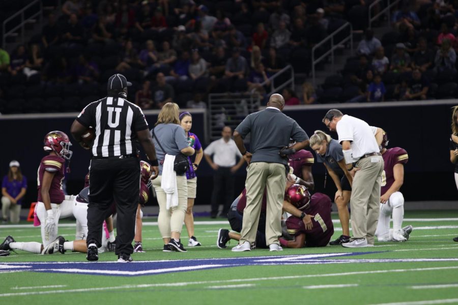 Athletic Trainers Coach Sharpe and Coach Kurowski examine senior Amare Jones’ broken ankle and fibula after being tackled in the Battle of Eldorado. Jones committed to Tulane University prior to this injury. 