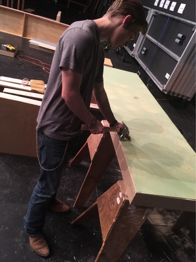 To begin the building process, junior Hinckley Petralia makes the first wall of the set.