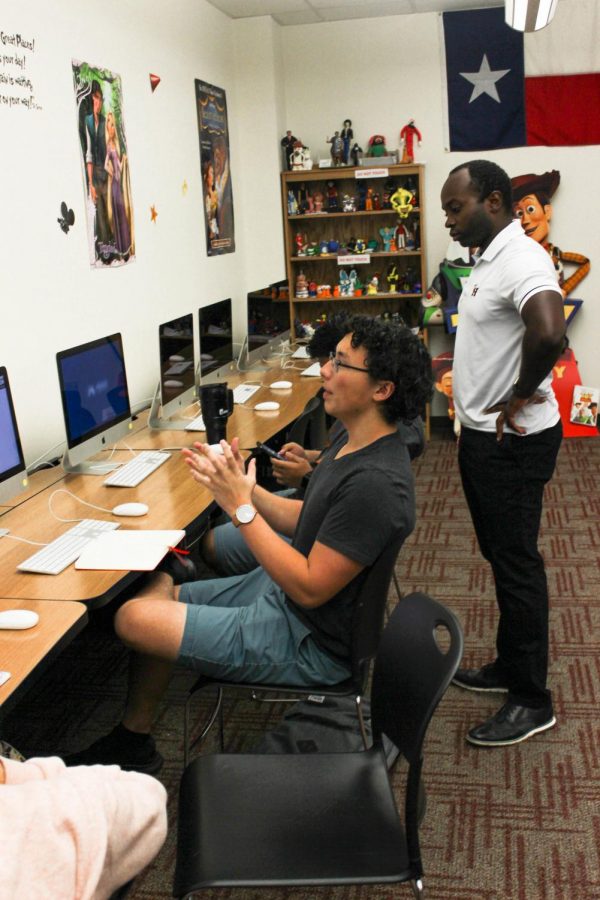 Senior Kai DeWitt sits to discuss possible logo designs in the group meeting. “I'm using everything I’ve learned about working in a studio environment to help guide the process of the logos design,” DeWitt said.